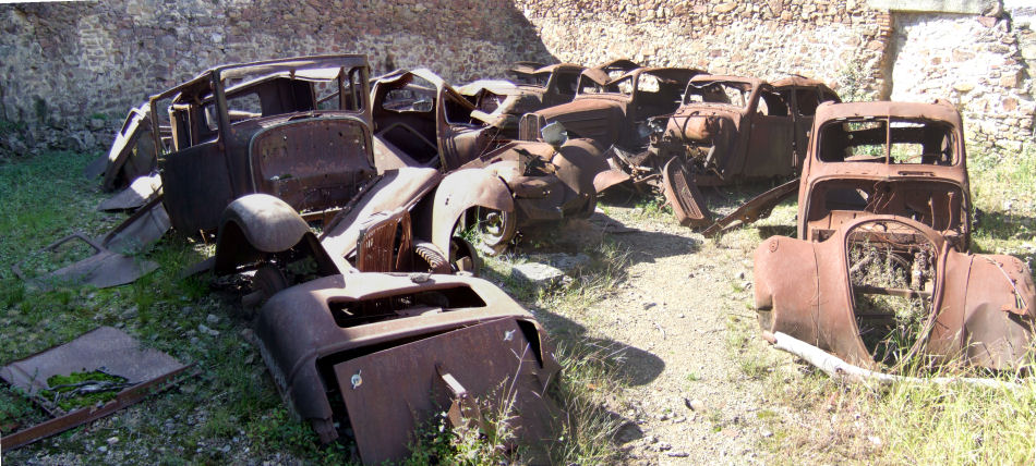 Panorama of ruined cars behind church in Oradour